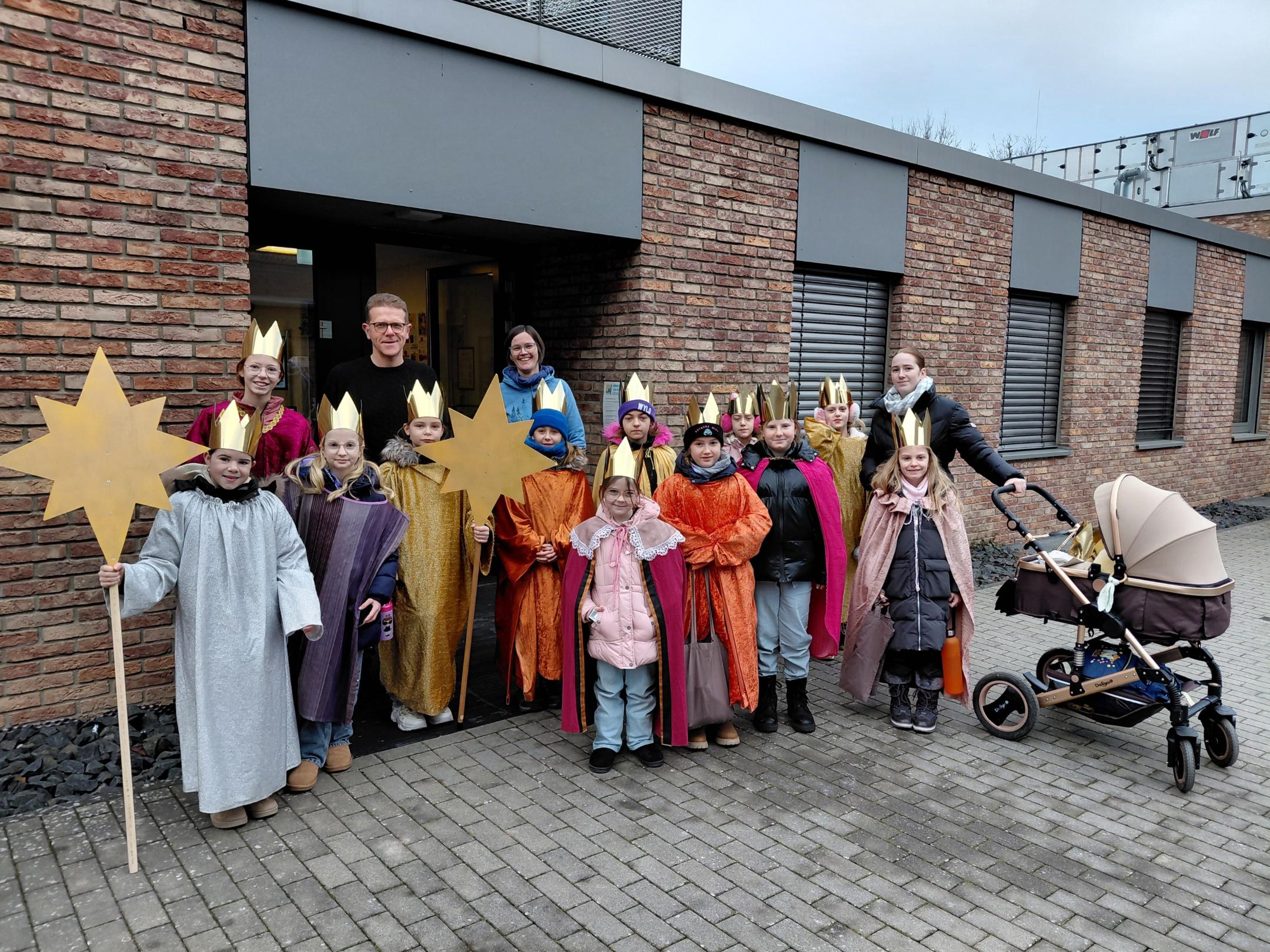 Sternsinger stehen vor dem Bürgerzentrum