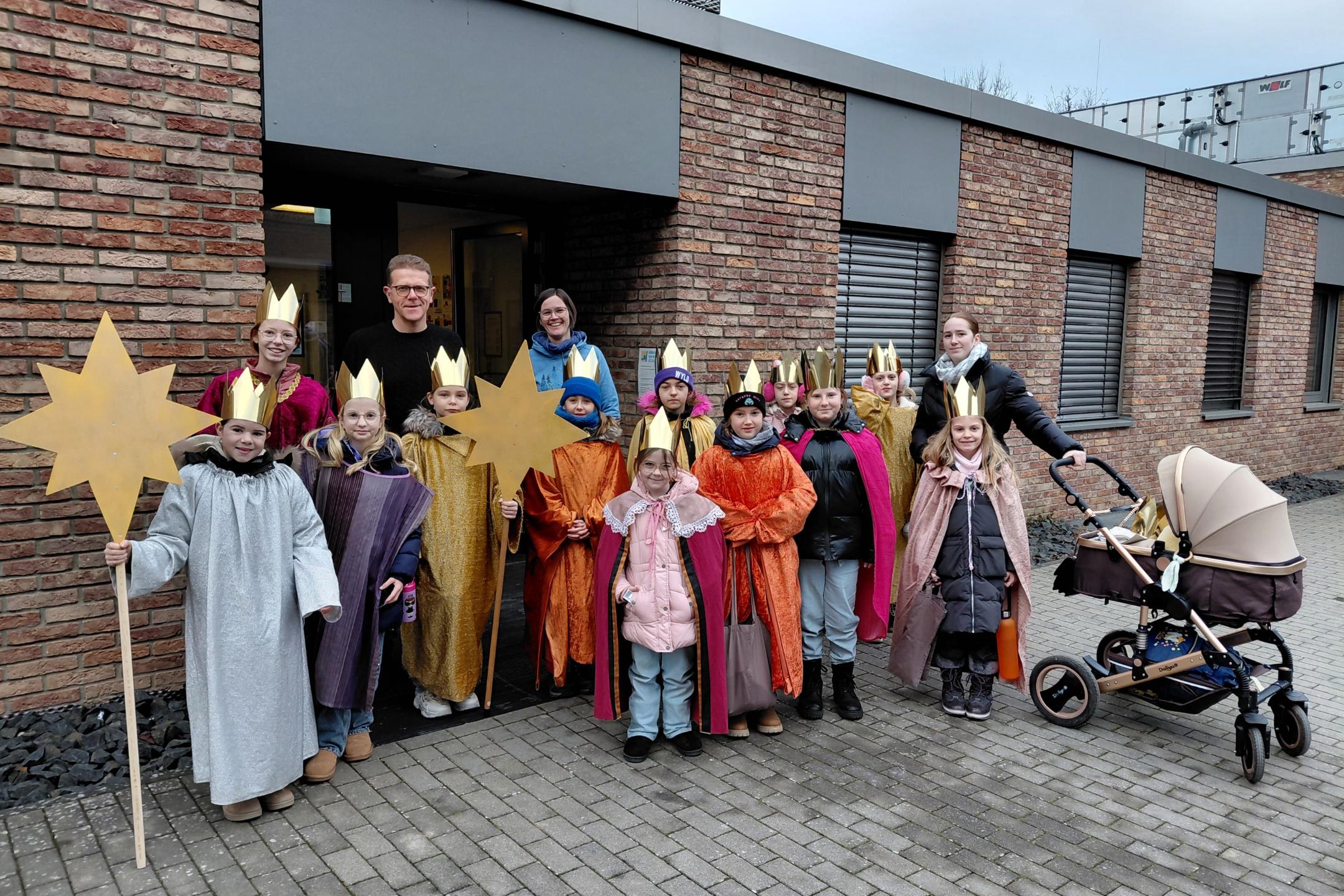 Sternsinger stehen vor dem Bürgerzentrum