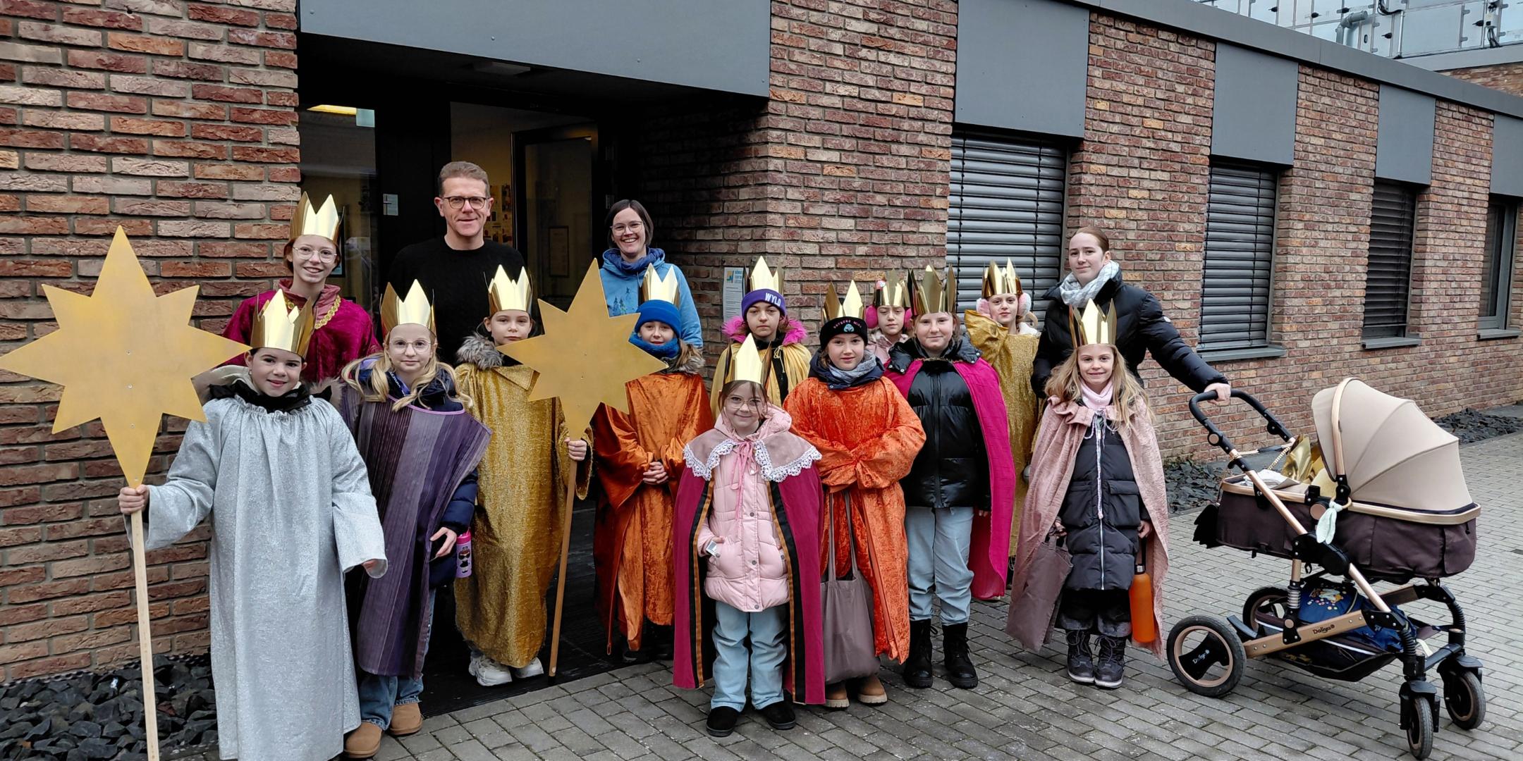 Sternsinger stehen vor dem Bürgerzentrum