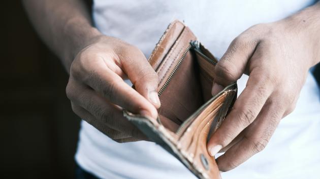 Ein Mensch hält eine leere Geldbörse in den Händen