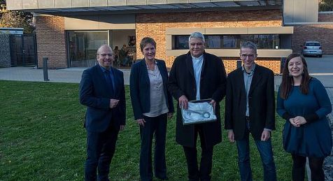 Menschen mit einem symbolischen Schlüssel feiern die Eröffnung des Bürgerzentrums
