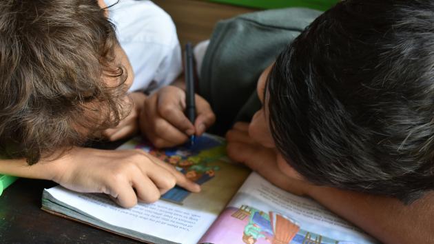 zwei Kinder schreiben in ein Buch