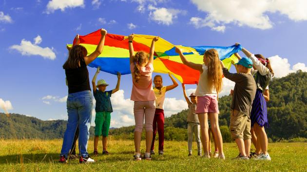 Kinder spielen mit einem Schwungtuch