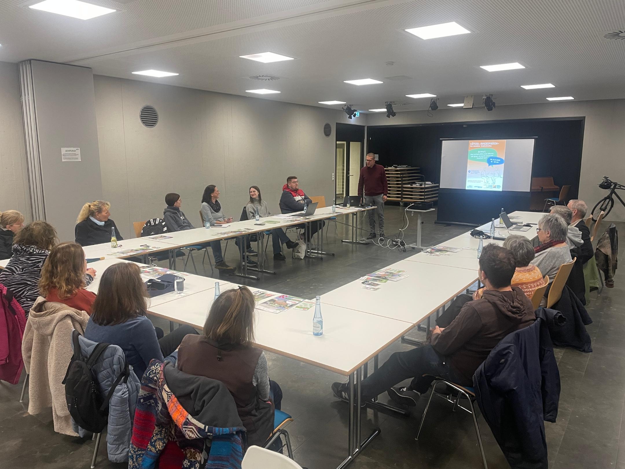 Menschen sitzen an Tischen und diskutieren