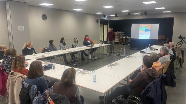 Menschen sitzen an Tischen und diskutieren