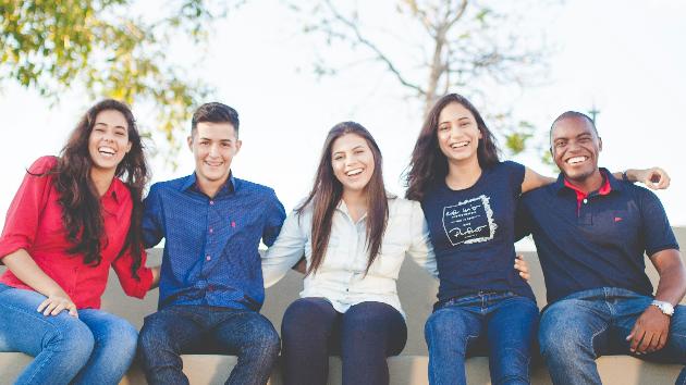 fünf junge Erwachsene sitzen zusammen