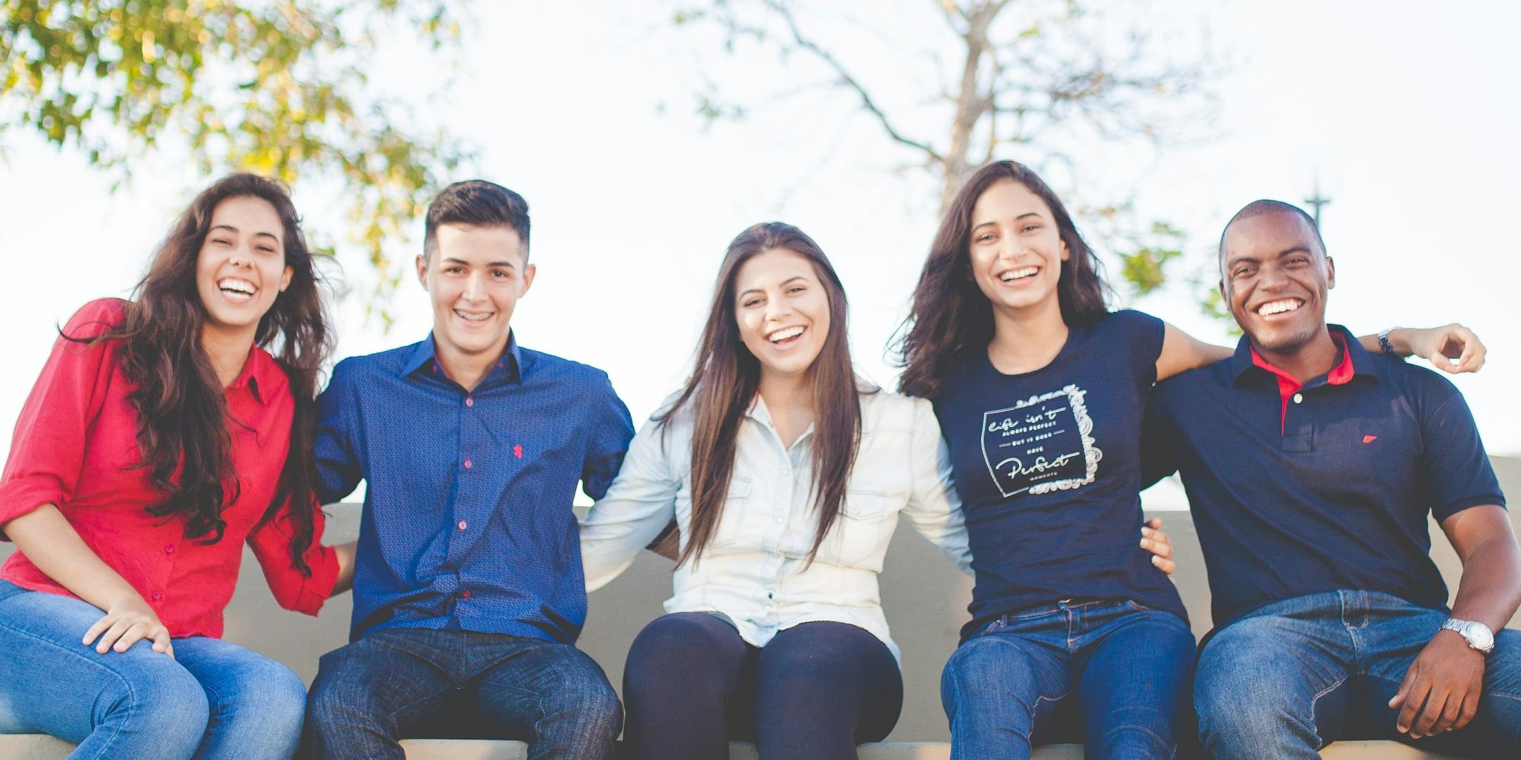 fünf junge Erwachsene sitzen zusammen