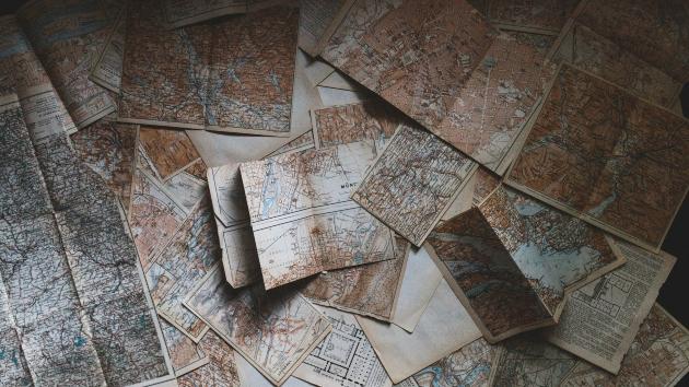 Historische Karten liegen verteilt auf einem Tisch