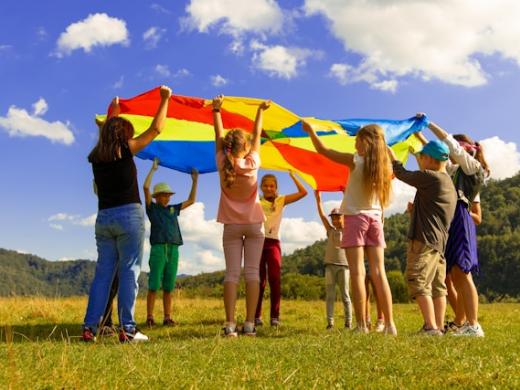 Kinder stehen mit einem Schwungtuch im Kreis