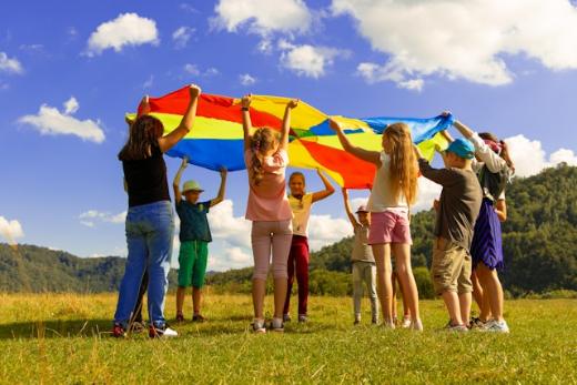 Kinder stehen mit einem Schwungtuch im Kreis